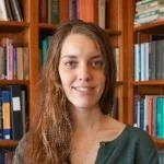 a white woman against a bookshelf