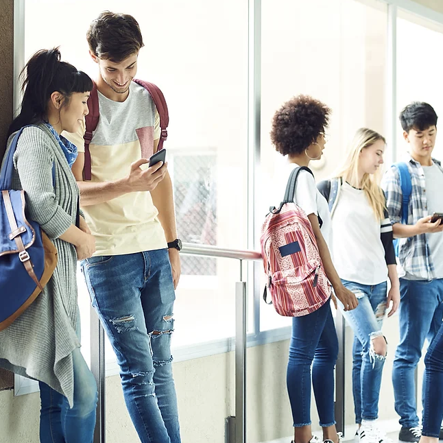 A group of teens standing in a school hallway